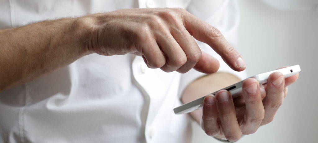 Image of a man using a mobile phone by Nordwood Themes taken from Unsplash